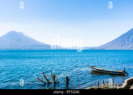 Atitlan, Toliman & San Pedro Vulkane auf Atitlan See mit Boot im Vordergrund günstig, Guatemala, Mittelamerika Stockfoto