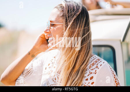 Blonde junge Frau am Telefon im Freien Stockfoto