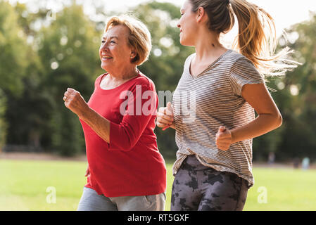 Enkelin und Oma Spaß, Joggen im Park Stockfoto