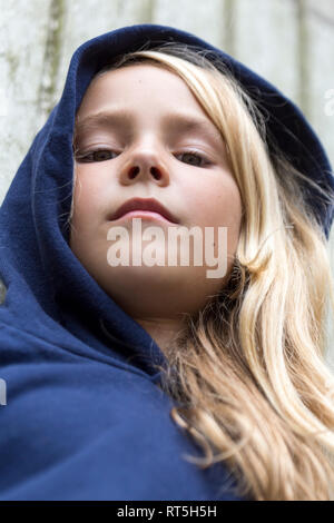 Porträt von Ernst blonde Mädchen trägt blaue Kapuzenjacke Stockfoto