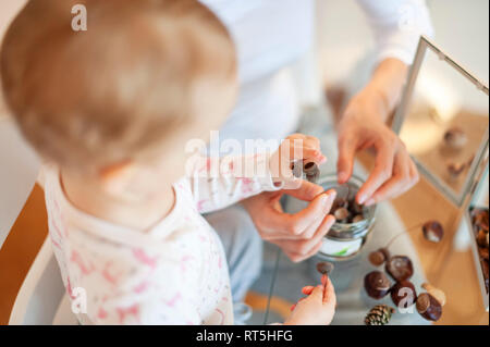 Nahaufnahme der Mutter und Tochter basteln mit herbstlichen Dekoration zu Hause. Stockfoto