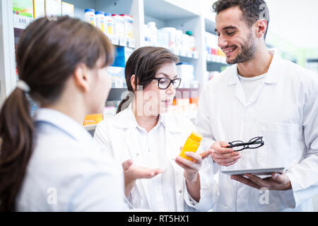 Zwei Apotheker beraten Kunden in der Pharmazie Stockfoto