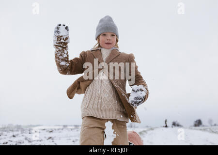 Glückliche junge spielt mit Schnee Stockfoto