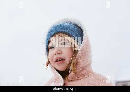 Portrait von kleinen Mädchen in Schneefall Stockfoto