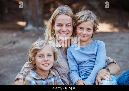 Portrait der glücklichen Mutter mit zwei Söhnen im Freien Stockfoto