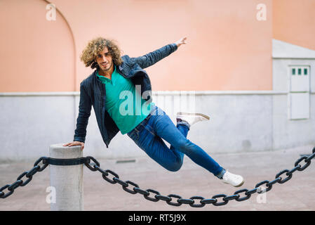 Portrait von lächelnden jungen Mann springen über Kette im Freien Stockfoto