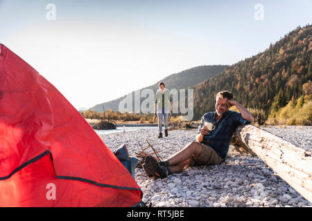 Reifes Paar camping am Flußufer im Abendlicht Stockfoto