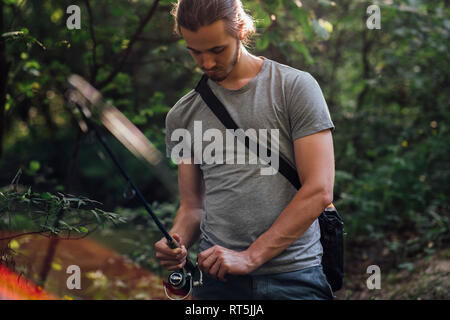 Junger Mann angeln in einem Wald Stockfoto