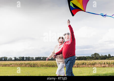 Gerne älteres Paar mit Kite in ländlichen Landschaft Stockfoto