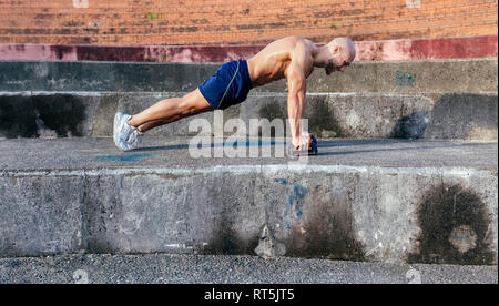 Barechested muskulösen Mann tun Push-ups im Freien Stockfoto