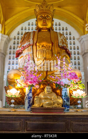 Chinesischer Buddha im Verbot Po Thar Pagode, Kek Lok Si buddhistischer Tempel. Kleine lächelnde Buddha im Vordergrund. George Town, Penang, Malaysia. Stockfoto