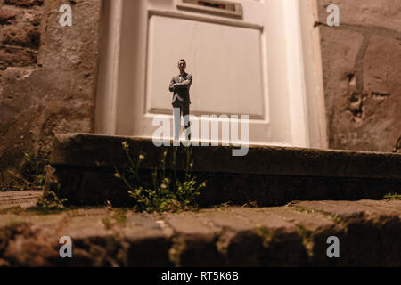 Geschäftsmann Figur stehend auf der Treppe vor der Eingangstür Stockfoto