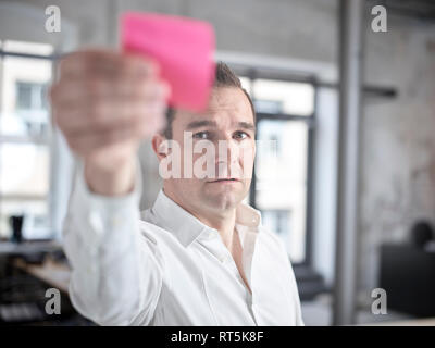 Geschäftsmann mit haftnotiz im Büro Stockfoto