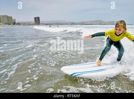 Chile, Arica, Happy Boy Surfen im Meer Stockfoto