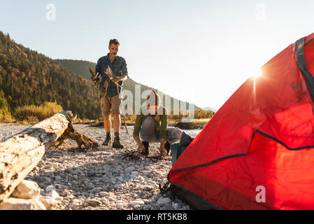 Reifes Paar camping am Flußufer, sammeln Holz für ein Lagerfeuer. Stockfoto