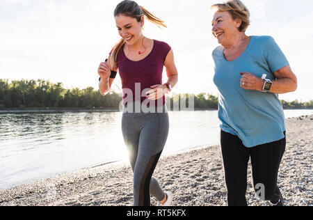 Enkelin und Oma Spaß, Joggen am Fluss Stockfoto