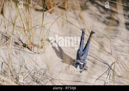 Geschäftsmann Figur in Sand stecken den Kopf Stockfoto