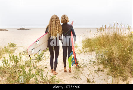 Spanien, Aviles, Ansicht von hinten von zwei jungen Surfer am Strand Stockfoto