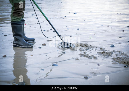 Mann mit Metalldetektor am Sandstrand Stockfoto