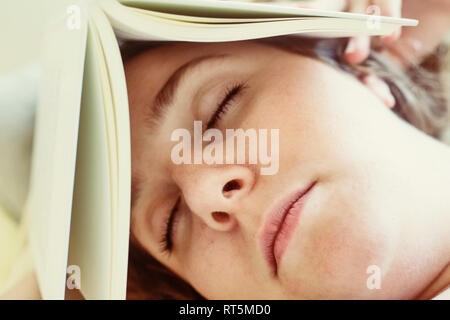 Porträt der jungen Frau schlafen mit Buch auf dem Kopf, close-up Stockfoto