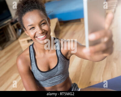Lächelnden jungen Frau in Sportkleidung, eine selfie Stockfoto