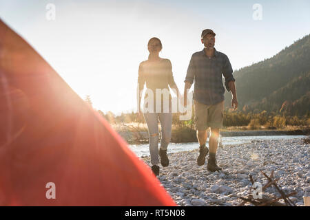 Reifes Paar camping am Flußufer im Abendlicht Stockfoto