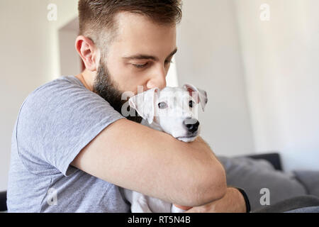 Mann seinen Hund zu Hause kuscheln Stockfoto