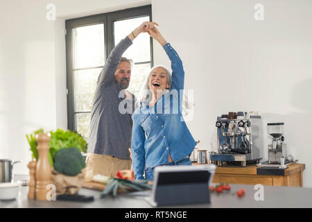 Jugendliche ältere Paare tanzen in der Küche Stockfoto