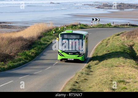 Widemouth Bay, Cornwall, England, Großbritannien. Februar 2019. Single Deck bus service Widemouth Bay, in der Nähe von Bude, North Cornwall vor der Kulisse der s Stockfoto