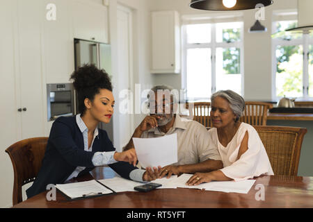 Weibliche real estate agent und Senior Paar diskutieren über Dokumente Stockfoto