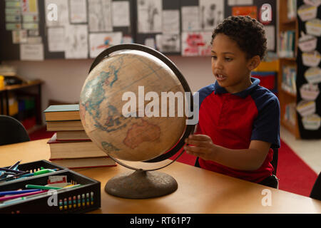 Schüler studieren weltweit am Schreibtisch in einem Klassenzimmer Stockfoto