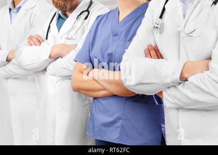 Ärzte und Krankenschwestern in healthcare Team mit Waffen in einer Reihe im Krankenhaus gekreuzt Stockfoto