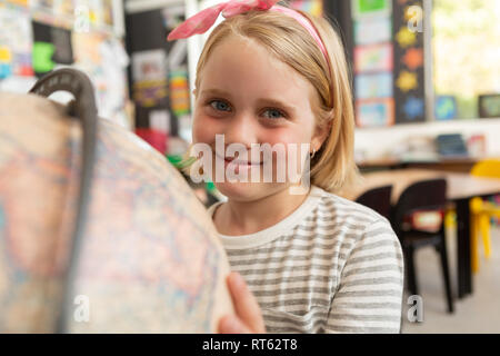 Schulmädchen Studium Kugel in einem Klassenzimmer Stockfoto