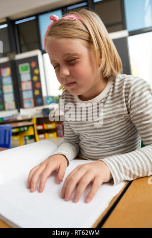 Blinde Schülerin lesen Sie ein Buch in Blindenschrift im Klassenzimmer Stockfoto