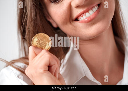 Digital Cash. Frau, die auf Weiß mit Münze toothy Lächeln schließen isoliert - oben Stockfoto