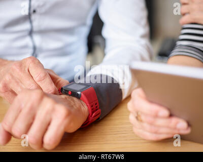 Nahaufnahme der Geschäftsmann und Geschäftsfrau mit smartwatch und Tablet im Büro Stockfoto