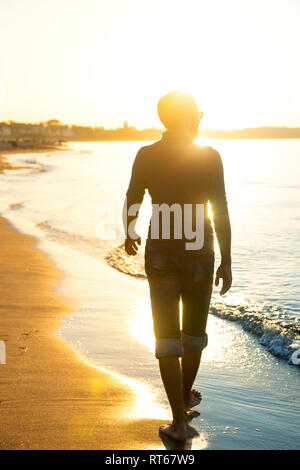 Silhouette der Mann am Strand bei Sonnenuntergang Stockfoto