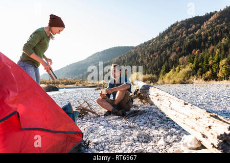 Reifes Paar camping am Flußufer im Abendlicht Stockfoto