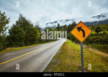 Chile, Puerto Aysen, Land Straße im Herbst mit Kurve Schild Stockfoto