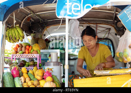 MYANMAR, Mandalay, 20. Mai 2018, asiatische Frau verkauft frisches Obst Getränke. Verkauf von Erfrischung in der Straße von einem Mobile Shop auf einem Auto. Stockfoto