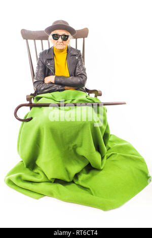 Alte Frau mit Hut und Sonnenbrille auf dem Stuhl Stockfoto
