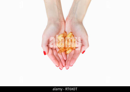 Die Streuung der transparent gelb Pillen. Handvoll Kapseln in der Handfläche, Nahaufnahme, auf weißem Hintergrund. Kapseln Fischöl, Omega 3. Gesundheit Stockfoto