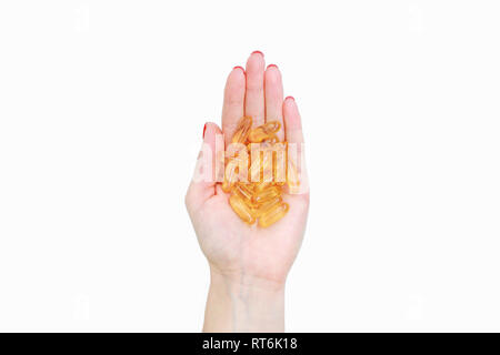 Die Streuung der transparent gelb Pillen. Handvoll Kapseln in der Handfläche, Nahaufnahme, auf weißem Hintergrund. Kapseln Fischöl, Omega 3. Gesundheit Stockfoto