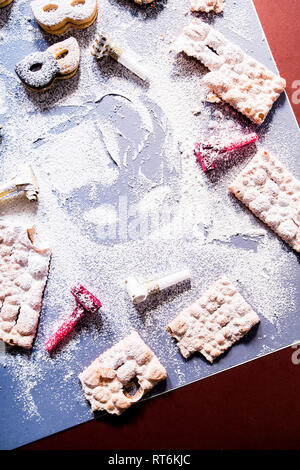 Karneval Konzept, Maske silhouette Eingekreist von Cookies und Süßwaren-typisch für Karneval, wie Italienische sfrappole oder Chiacchiere, Karneval frittiertes Gebäck, f Stockfoto