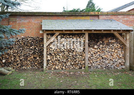 Speichern mit cut Brennholz in einem Garten gefüllt Stockfoto