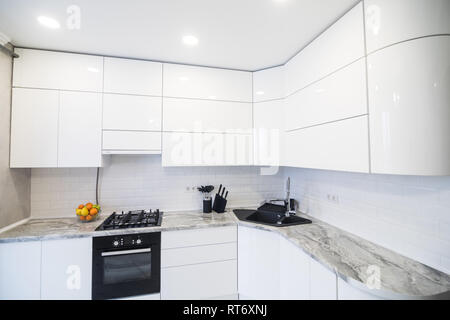 Moderne elegante weiße Küche mit Walnuss Insel Stockfoto