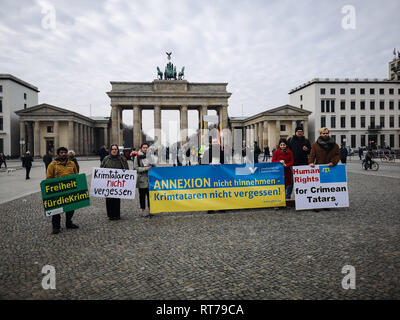 Februar 26, 2019 - eine kleine Gruppe von Menschen halten Fahnen vor dem Brandenburger Tor in Berlin aus Protest gegen die Annexion der Krim durch Russland und die EU auf, Druck auf Russland durch Sanktionen zu gewährleisten. Der Protest wurde organisiert von der Gesellschaft für bedrohte Menschen, die besorgt ist, die Rechte der Krimtataren seit der Annexion der Halbinsel durch Russland (Credit Bild: © Abdelwaheb Omar/IMAGESLIVE über ZUMA Draht) Stockfoto