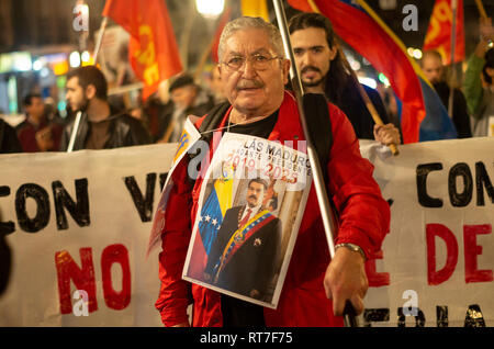 Madrid, Spanien. 28 Feb, 2019. Hunderte von Menschen protestierten gegen die Intervention der Vereinigten Staaten in Venezuela Marsch von Atocha zum Puerta del Sol in Madrid. Im Bild, ein Mann in den Protest Holding der Flagge Venezuelas und mit einem Plakat, das sagt "Nicolás Maduro Präsident 2019-2025 "Credit: Lora Grigorova/Alamy leben Nachrichten Stockfoto