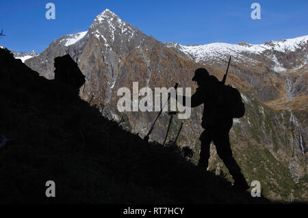 Silhouette der Jäger in South Westland der südlichen Alpen, Neuseeland Stockfoto