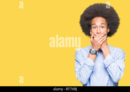 Junge afrikanische amerikanische Mann mit afro Haar schockiert über den Mund mit Händen für Fehler. Geheime Konzept. Stockfoto